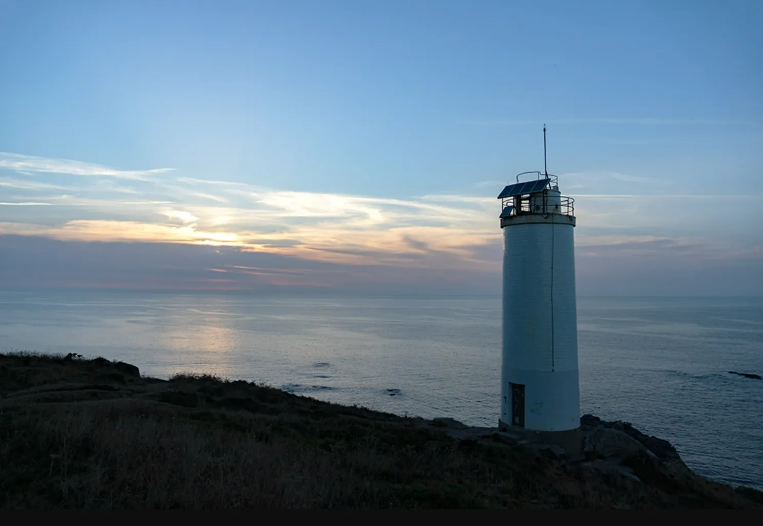 Faro de Laxe (Punta Insua) al atardecer sobre el mar de la Costa da Morte