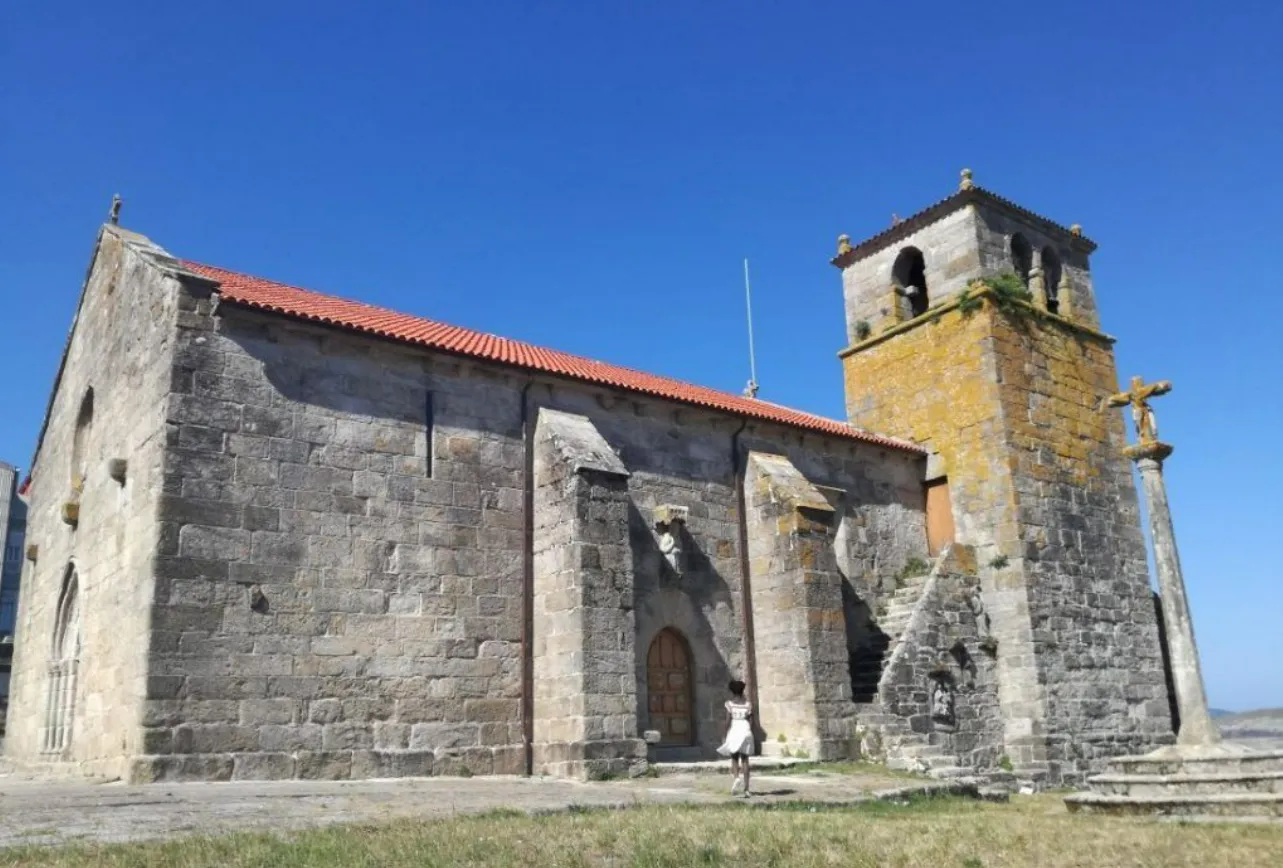 Santa María da Atalaia church in Laxe with the stone cruceiro in the foreground
