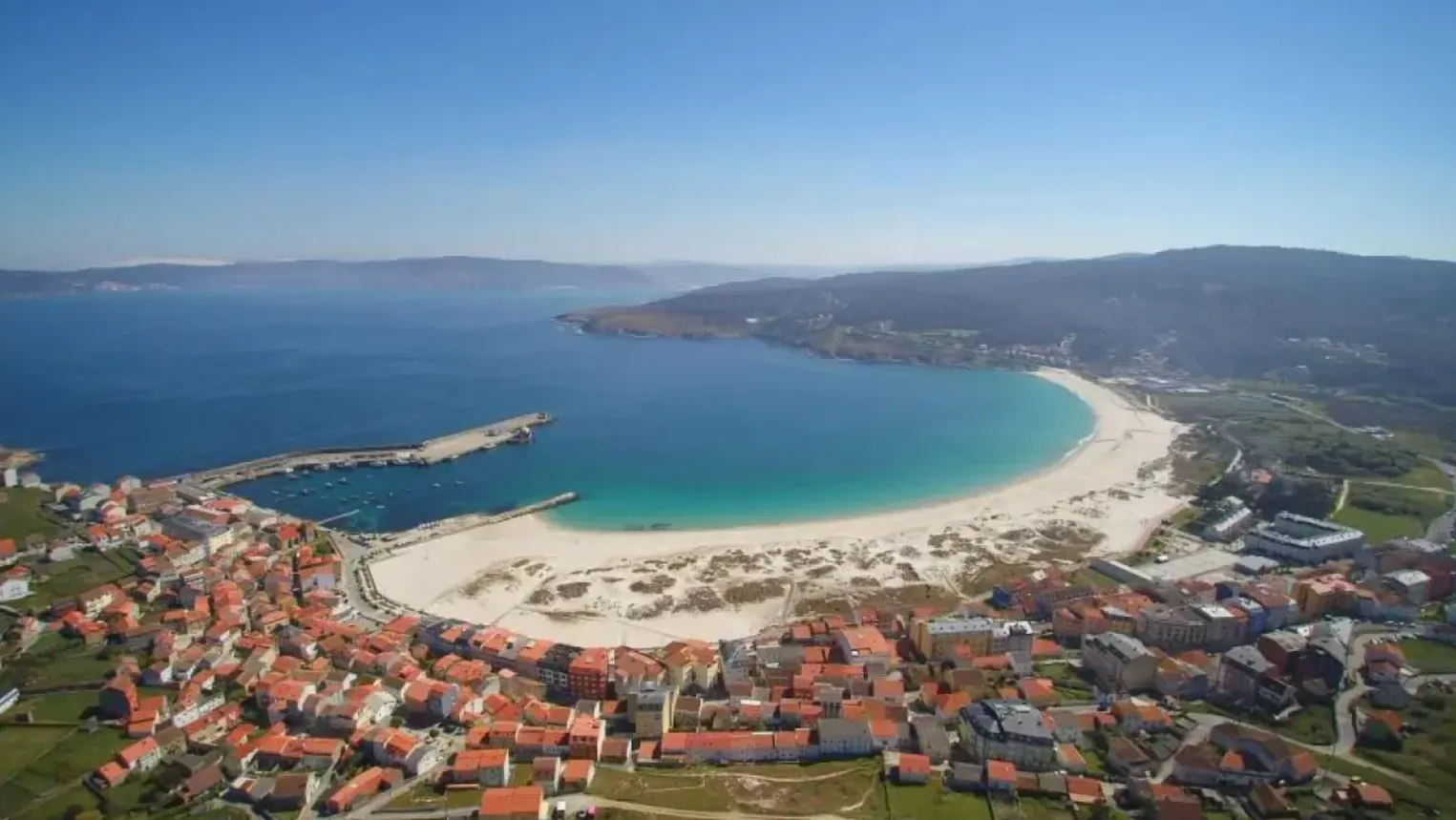 Vista aérea de Laxe con su gran playa de arena blanca y el puerto en la Costa da Morte