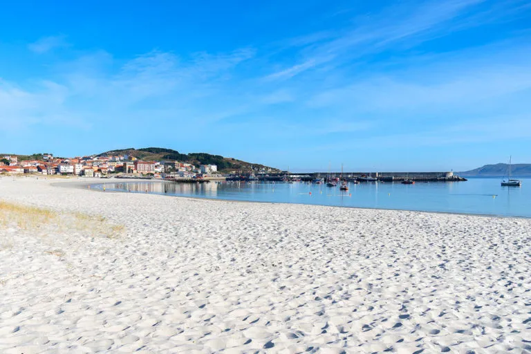 Praia de Laxe with its fine white sand and the village behind